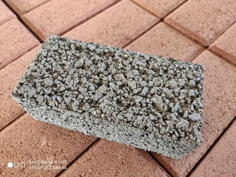 Close de paver drenante poroso ao lado de paver comum